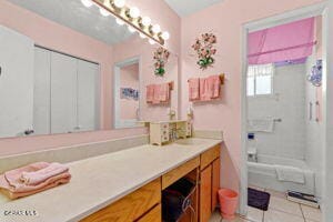 bathroom with bathing tub / shower combination, vanity, and tile patterned floors