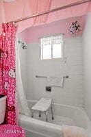 bathroom with shower / bath combo with shower curtain