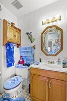 bathroom featuring vanity, tile patterned floors, and toilet