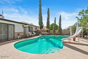 view of pool with a water slide and a patio