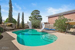 view of swimming pool with a patio and a water slide