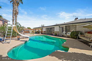 view of pool featuring a water slide and a patio area