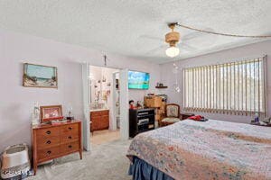 carpeted bedroom with ceiling fan and a textured ceiling