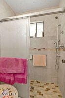 bathroom with a shower with door