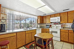 kitchen with light tile patterned floors, white appliances, sink, and a textured ceiling