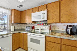 kitchen with white appliances and decorative backsplash