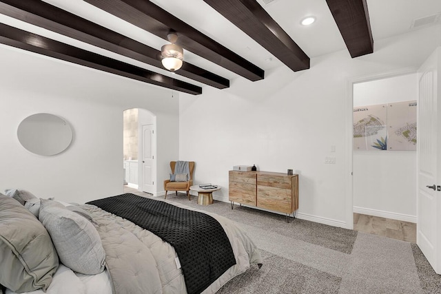 bedroom with beamed ceiling, ceiling fan, and ensuite bathroom