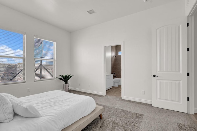 carpeted bedroom featuring ensuite bathroom