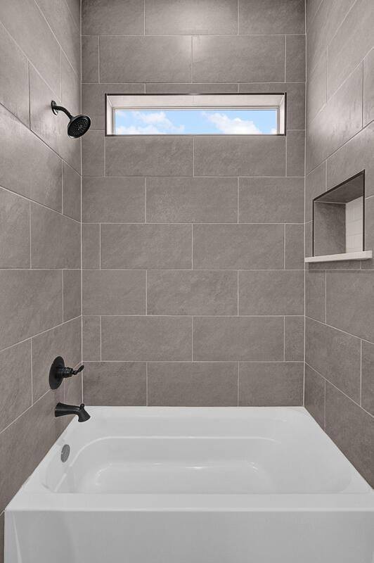 bathroom featuring tiled shower / bath and a wealth of natural light