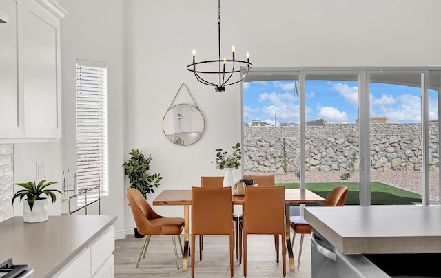 dining space featuring light hardwood / wood-style flooring, a chandelier, and a healthy amount of sunlight