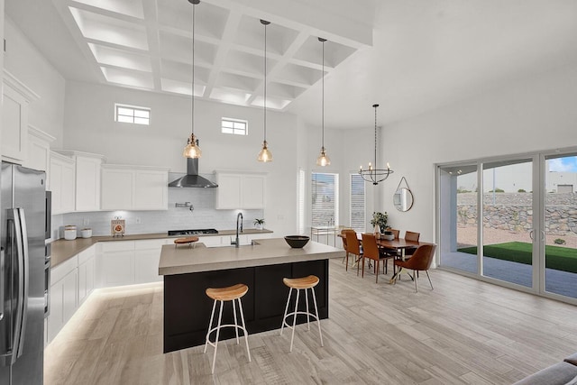 kitchen with tasteful backsplash, white cabinets, and stainless steel refrigerator