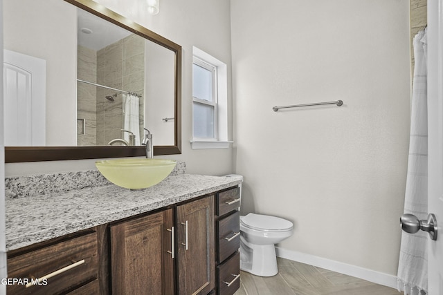 bathroom with toilet, vanity, and a shower with shower curtain