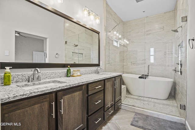 bathroom featuring ceiling fan, vanity, and shower with separate bathtub