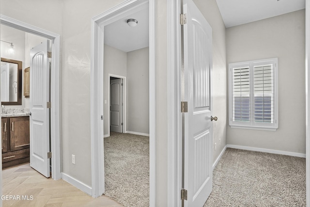 hallway with a wealth of natural light and light colored carpet