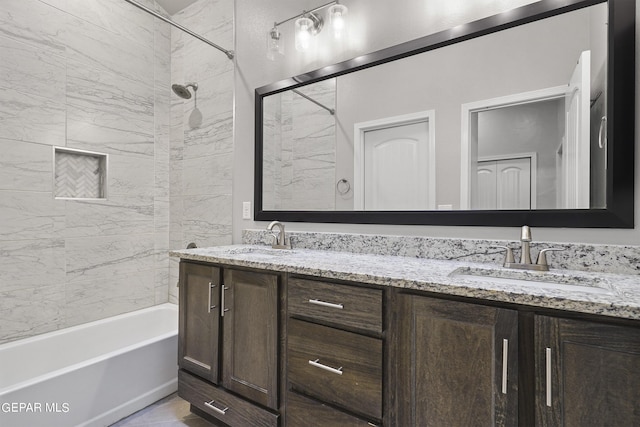 bathroom with tiled shower / bath combo and vanity