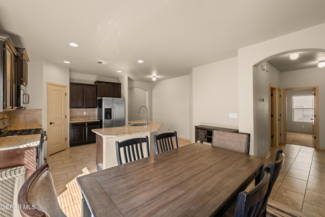 dining room with sink and light colored carpet