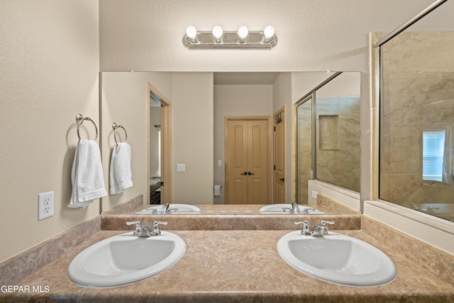 full bathroom featuring a sink, a shower stall, and double vanity