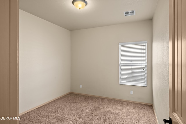 carpeted empty room featuring visible vents and baseboards