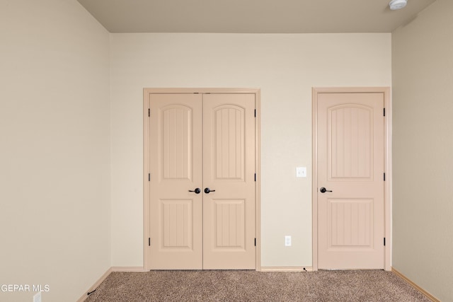 unfurnished bedroom featuring carpet floors, a closet, and baseboards