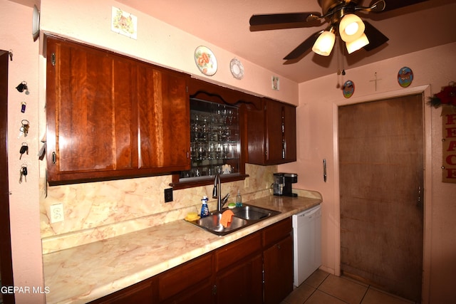 kitchen featuring ceiling fan, light tile flooring, backsplash, white dishwasher, and sink