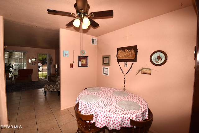 dining space with tile floors and ceiling fan