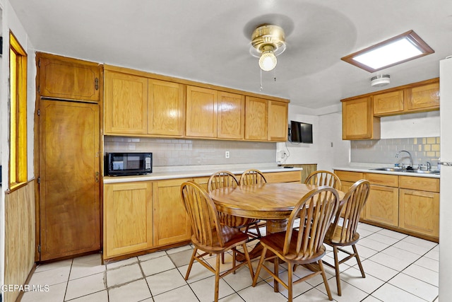 kitchen featuring ceiling fan, light tile patterned floors, sink, and tasteful backsplash