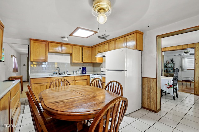 kitchen featuring light tile patterned floors, white appliances, ceiling fan, and sink