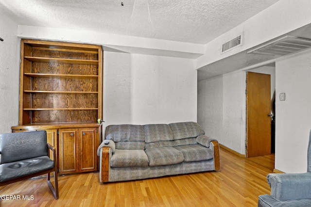 living room featuring light hardwood / wood-style floors and a textured ceiling