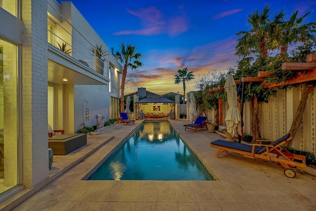 928 Singing Hills Dr, El Paso, TX 79912 - pool at dusk featuring a gazebo, a fenced in pool, a fenced backyard, and a patio