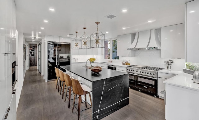 928 Singing Hills Dr, El Paso, TX 79912 - kitchen featuring visible vents, wall chimney range hood, a sink, modern cabinets, and double oven range