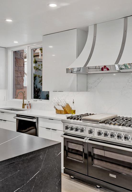 928 Singing Hills Dr, El Paso, TX 79912 - kitchen with dishwashing machine, a sink, wall chimney exhaust hood, range with two ovens, and white cabinetry
