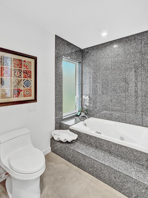 928 Singing Hills Dr, El Paso, TX 79912 - bathroom with tile patterned flooring, toilet, and a tub with jets