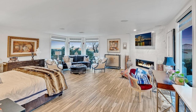 928 Singing Hills Dr, El Paso, TX 79912 - bedroom featuring wood finished floors, a large fireplace, and recessed lighting