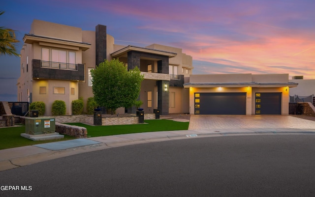 view of front of home with a garage and a balcony