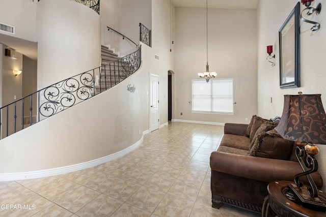 living room with light tile patterned floors, a notable chandelier, and a towering ceiling