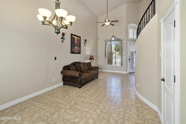 tiled foyer with high vaulted ceiling and ceiling fan with notable chandelier