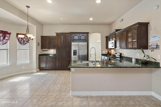 kitchen with dark brown cabinets, sink, kitchen peninsula, pendant lighting, and stainless steel appliances