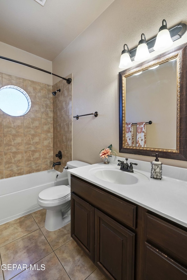 full bathroom with tile patterned floors, toilet, vanity, and tiled shower / bath