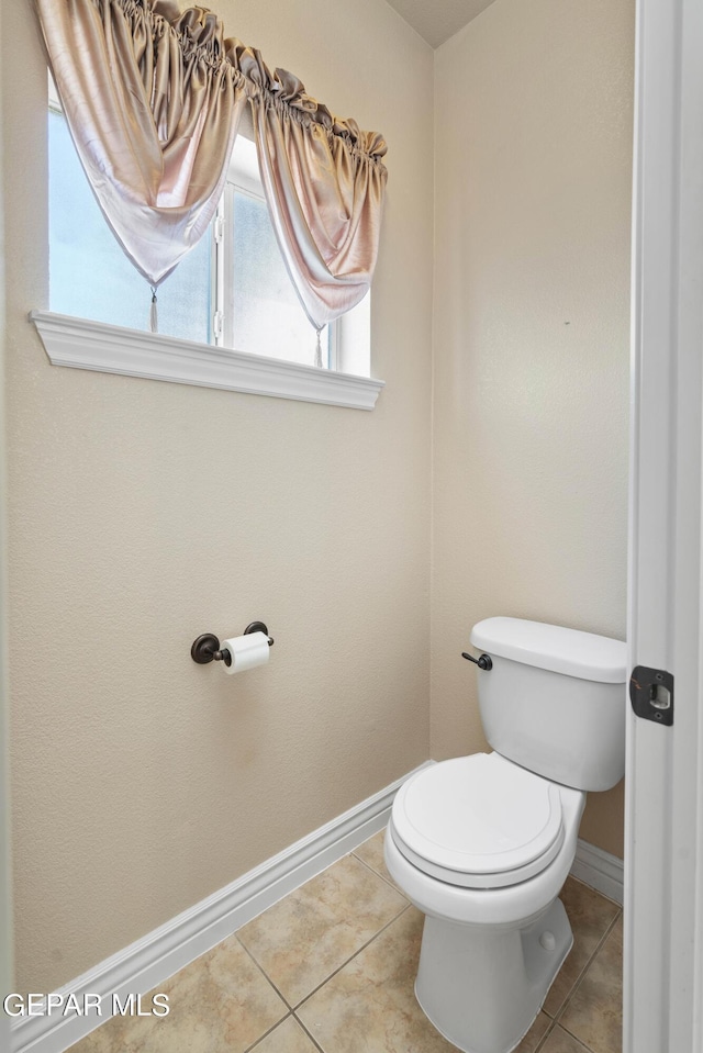 bathroom featuring toilet and tile patterned flooring