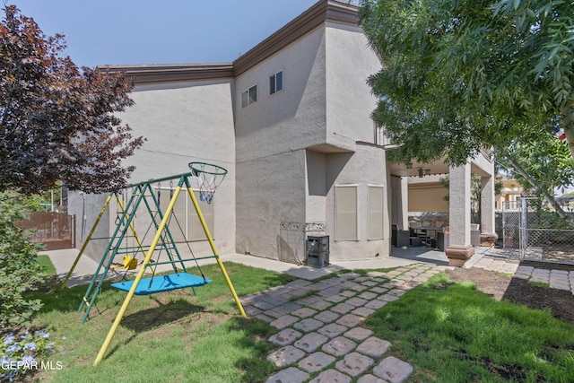 rear view of house featuring a patio area and a playground