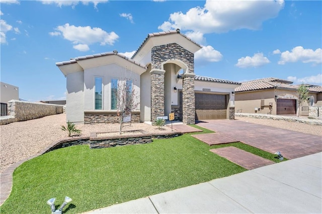 mediterranean / spanish home featuring a front yard and a garage