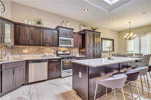 1701 Bull Ring St, El Paso, TX 79928 - kitchen with appliances with stainless steel finishes, light stone counters, sink, pendant lighting, and a chandelier