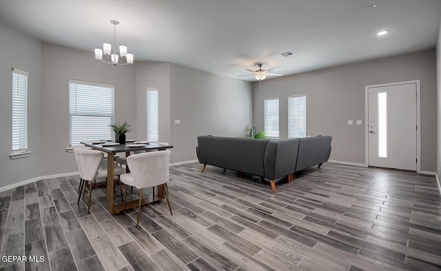 dining space featuring hardwood / wood-style flooring and ceiling fan with notable chandelier