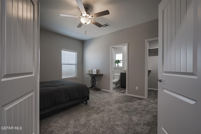 bedroom featuring ceiling fan, dark carpet, and ensuite bath