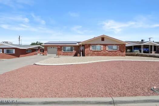 ranch-style house featuring solar panels and a garage