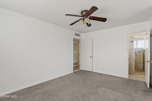 unfurnished bedroom with ensuite bath, ceiling fan, carpet floors, and a textured ceiling