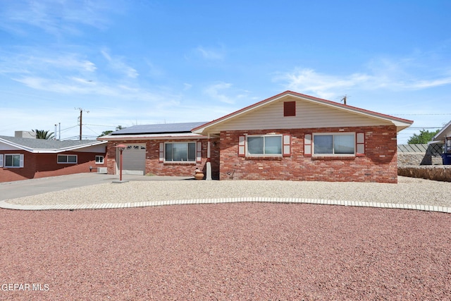 single story home with solar panels and a garage