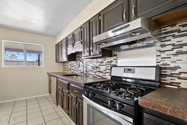 kitchen featuring gas stove, dark brown cabinetry, sink, decorative backsplash, and light tile patterned floors