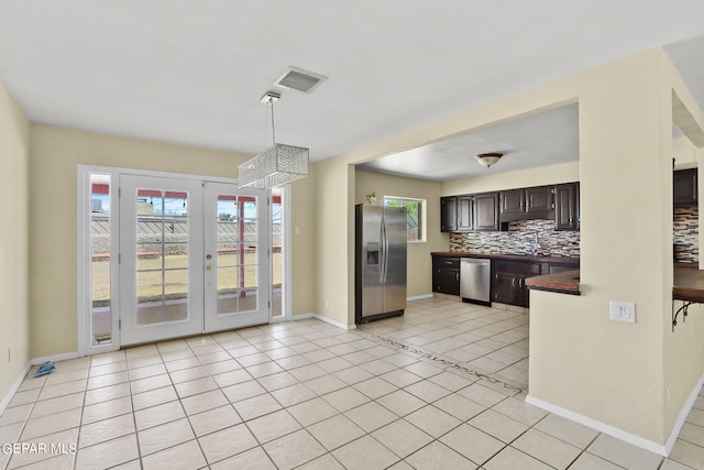 kitchen with tasteful backsplash, dark brown cabinets, light tile patterned floors, and stainless steel appliances