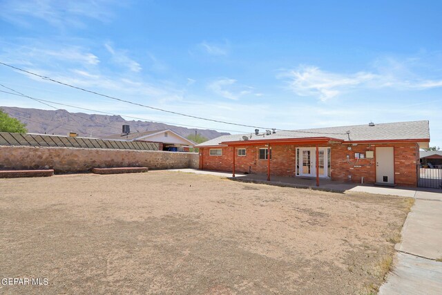 rear view of house with a mountain view and french doors